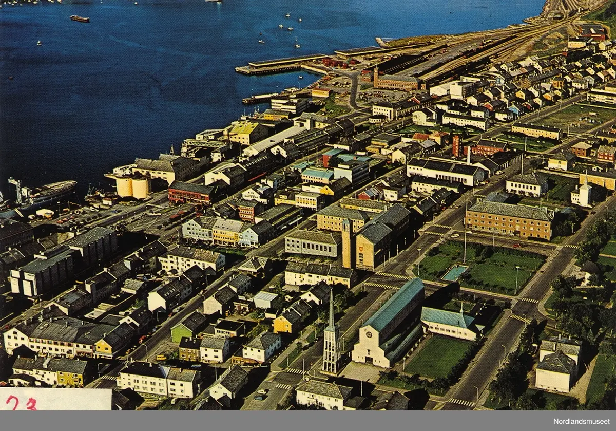Prospektkort. Flyfoto over deler av Bodø sentrum mot havna ...