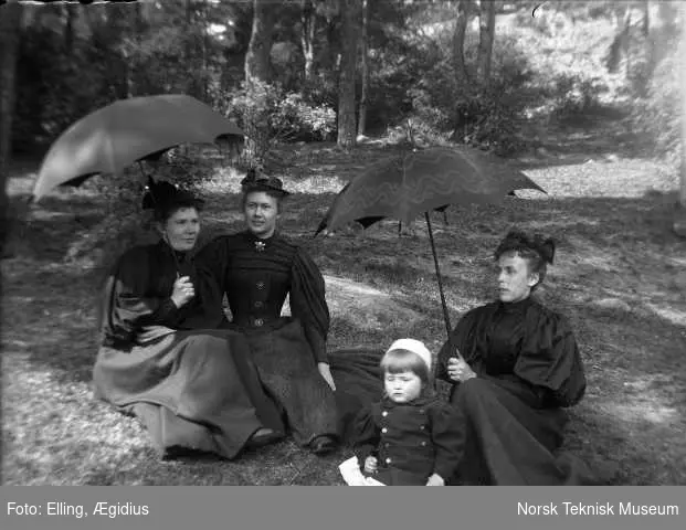 Ægidius Ellings familie på skogtur i sorte kjoler og paraply