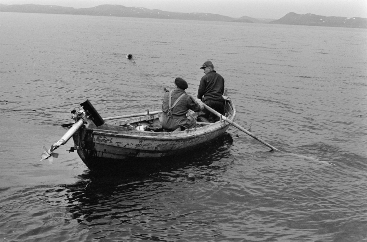 Folk i båt på garnfiske.