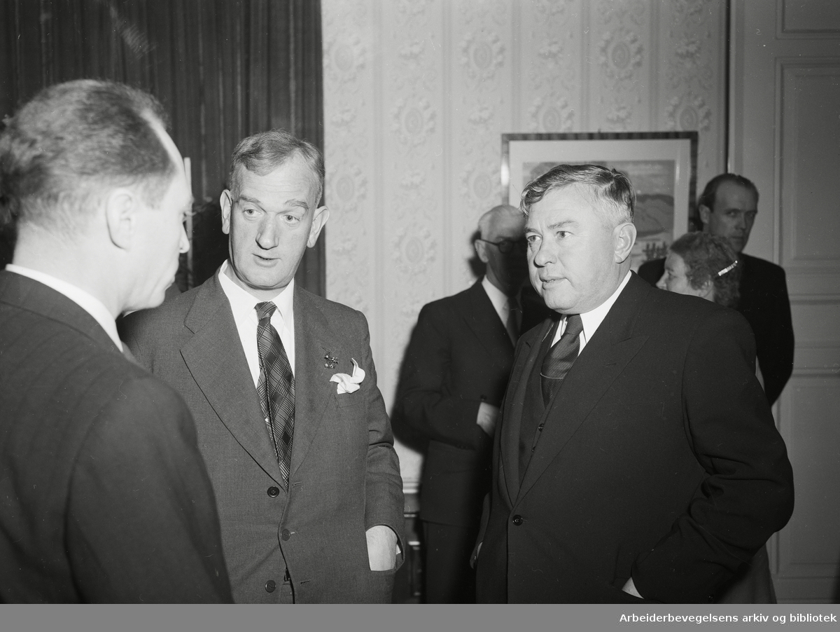 Stortinget er invitert på kaviar og vodka i den sovjetrussiske ambassaden. Fra venstre: ukjent, senere stortingspresident Nils Langhelle fra Arbeiderpartiet og ambassadør Georgij Arkadjev. 21. April 1955.