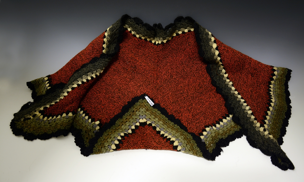 Trekantsjal strikket i rød og brun ull med heklet kant.