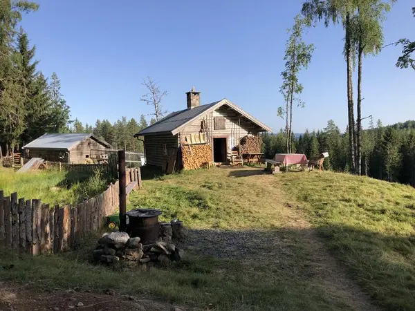 Skålbergsætra en sommerdag. Skyblå himmel. Grønt gress rundt sætra.