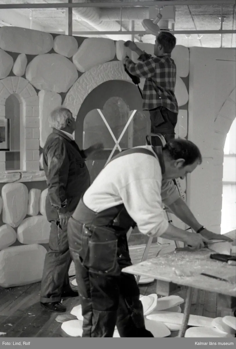 Utställningen Medeltidens Kalmar under byggnad. Alf formar en liten "sten", Magnus sätter upp och Maffi tittar på.
