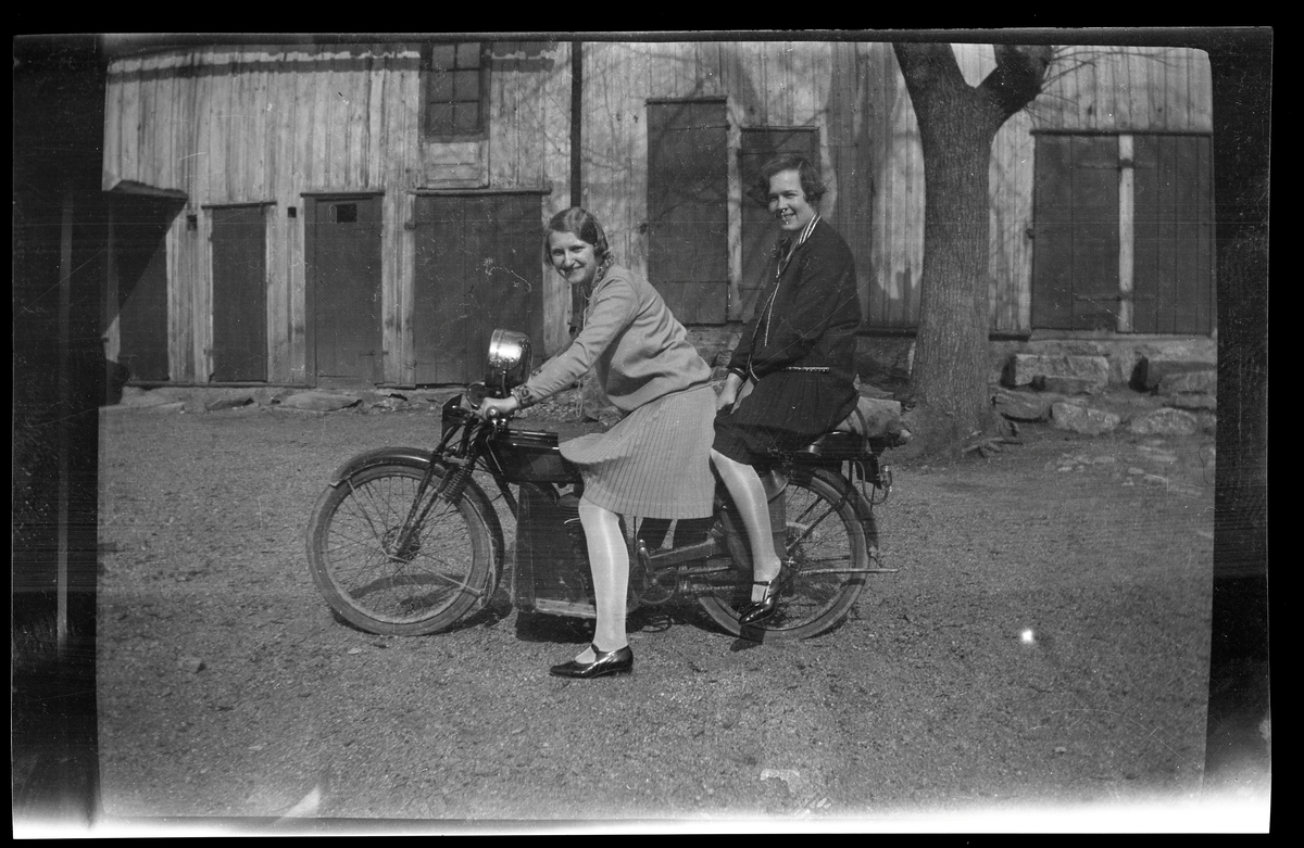 Två kvinnor sitter på en motorcykel.