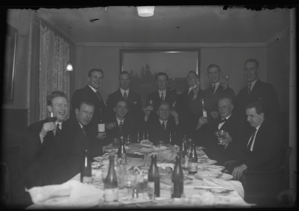 Ett antal män skålar vid festbordet.