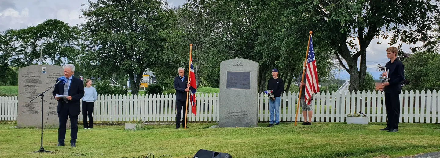 Kranseseremoni ved bautastein, flaggvakt med flagg fra Norge og USA