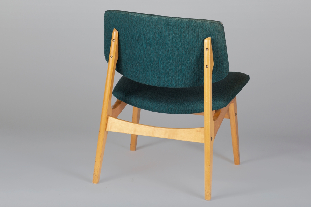 Stol i laminert tre med polstret sete og ryggbrett, trukket i grønt stoff. Sprossen foran og bak er buet i overkant. Sidesprossene utgjør delvis stolens sarg.