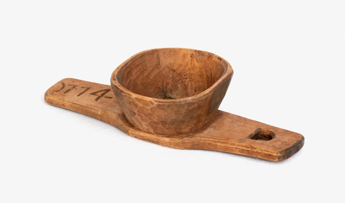Silträ, mjölksil, från Sundborn. Trä. Silen består av en tratt på ett silträ i ett stycke trä. Botten har en fyrkantig genombrytning ca 35 mm i kvadrat täckt med en perforerad kopparplåt. Årtal: "1774".