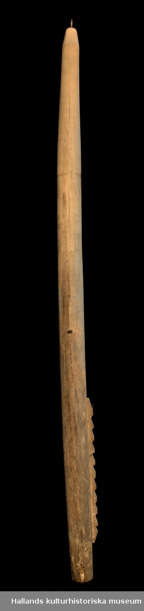 Skrapstock. Tillverkad av granvirke. Trubbig spets. Den nedre änden av stocken är plant avsågad. Ändarna är försedda med varsin järnpigg. På mitten av stocken sitter två järnöglor. På stockens nedre del sitter en 40cm lång räfflad utbyggnad fastspikad.