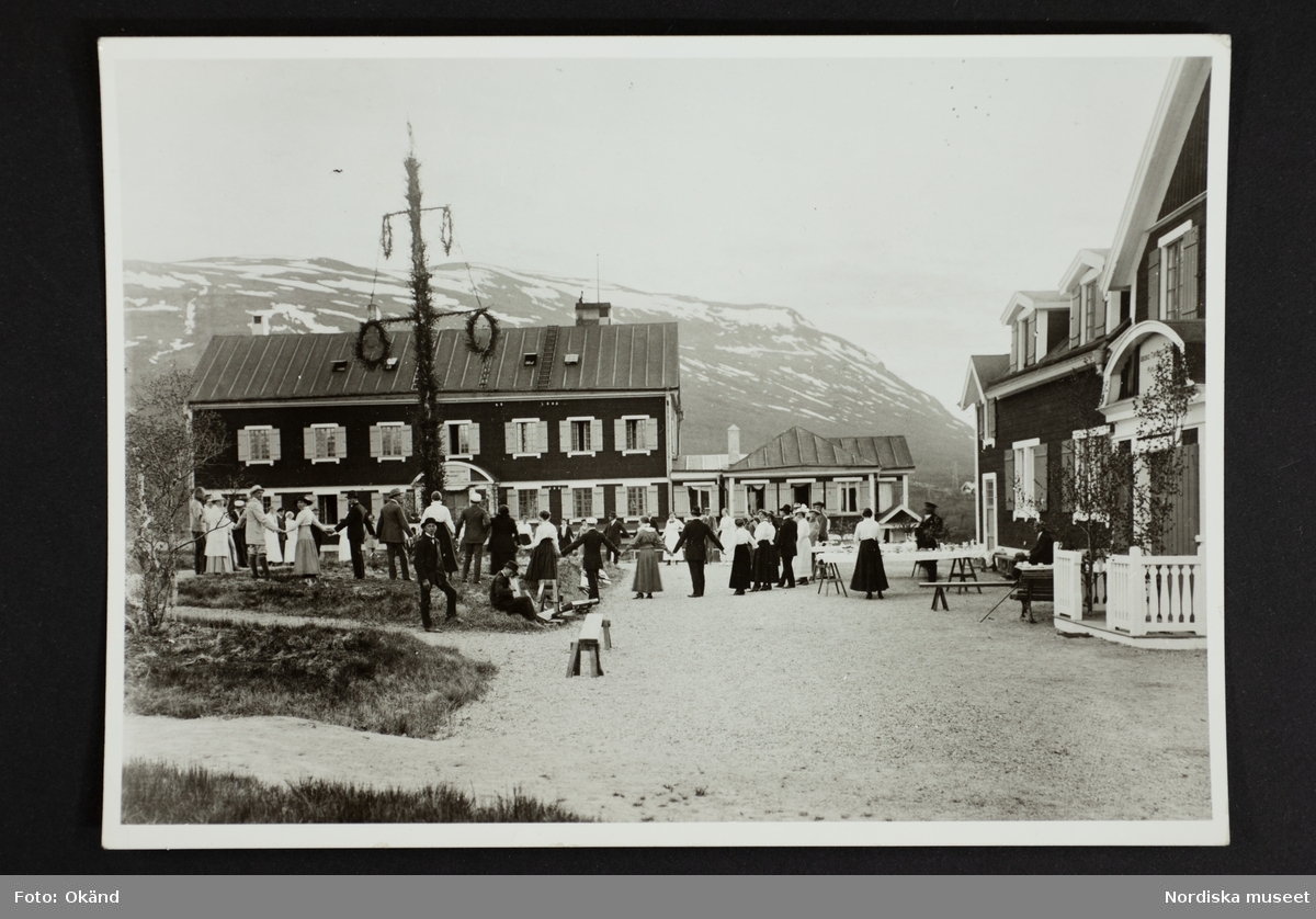 Dans runt majstången vid Abisko turiststation. "1907 fullbordades den s k paviljongen vid Abisko turiststation. I stora drag såg anläggningen ut likadant ända till 1949, då hela stationen brann upp. Den byggdes upp igen - i tegel!"
