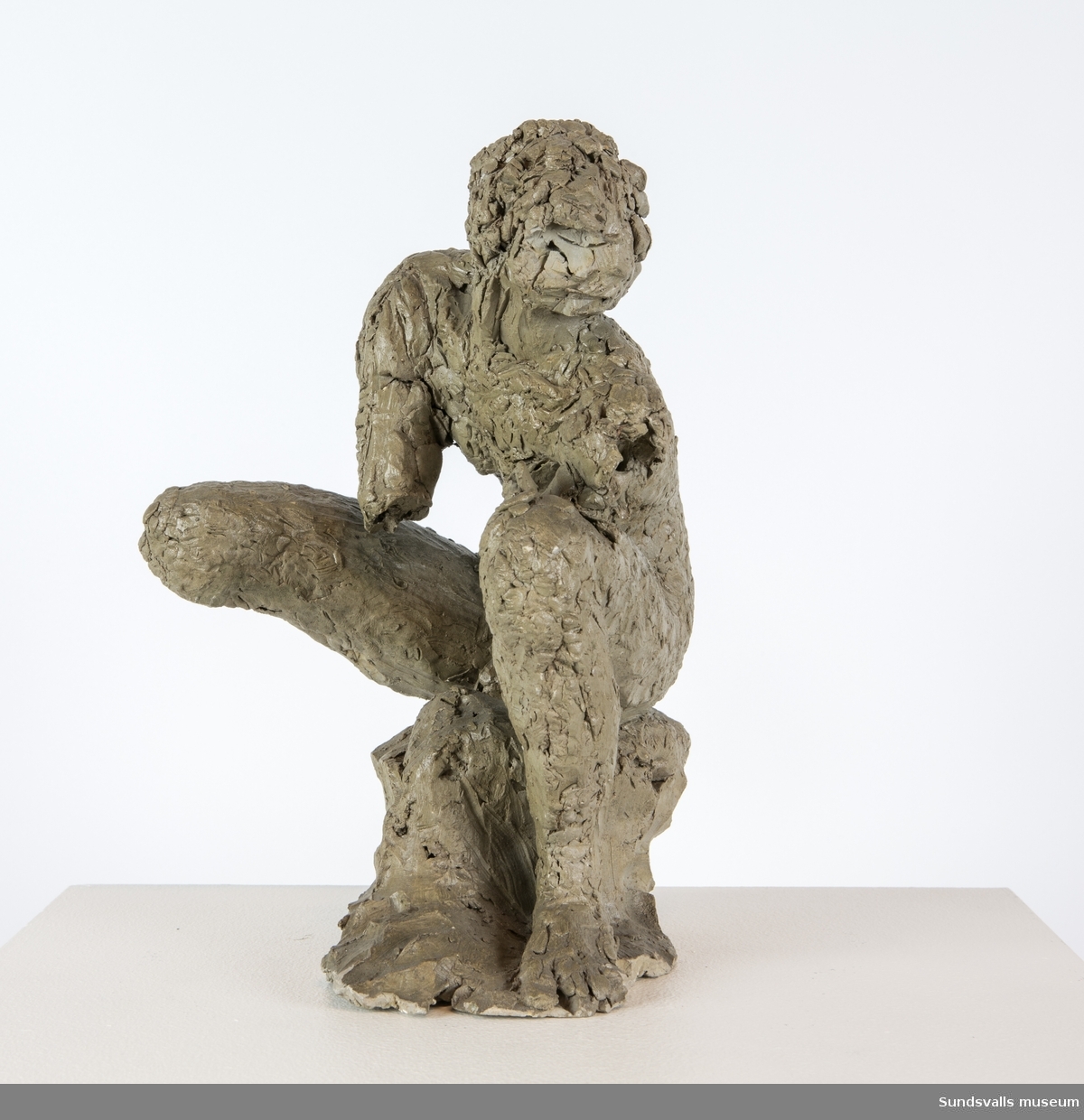 En skulptur i form av en sittande man.