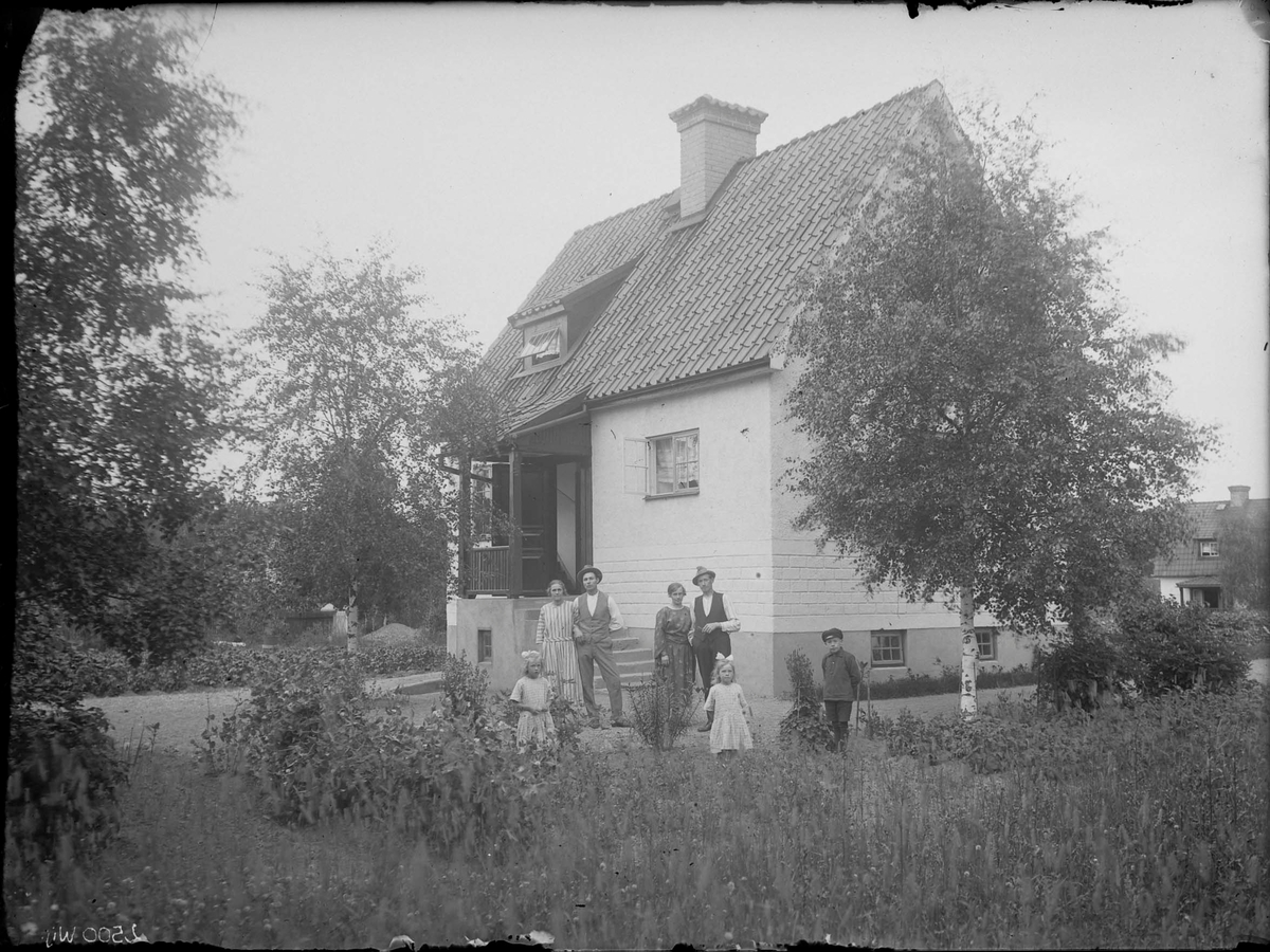 Fotografering beställd av Karlsson. I bild syns sannolikt Axel Emanuel Karlsson (1894-1928) och hans hustru Eva Jakobsson (1896-1988) med sonen Erik Tage Emanuel (1915-1996) längst till höger. Bosatta på Haga 28. De andra är ej identifierade.
