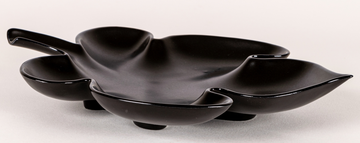 Lövformad skål i flintgods, modell EE, glasyr Mangania. Formgiven av Lillemor Mannerheim 1950.