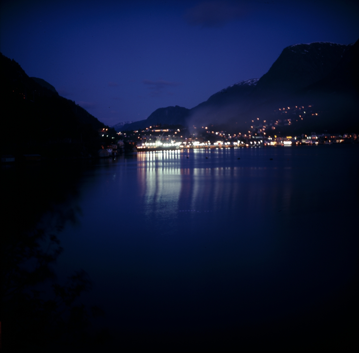 Nattfoto av Odda.  Fra fotografens originalemballasje: Odda v. Hardangerfjorden F2    3.6.1972