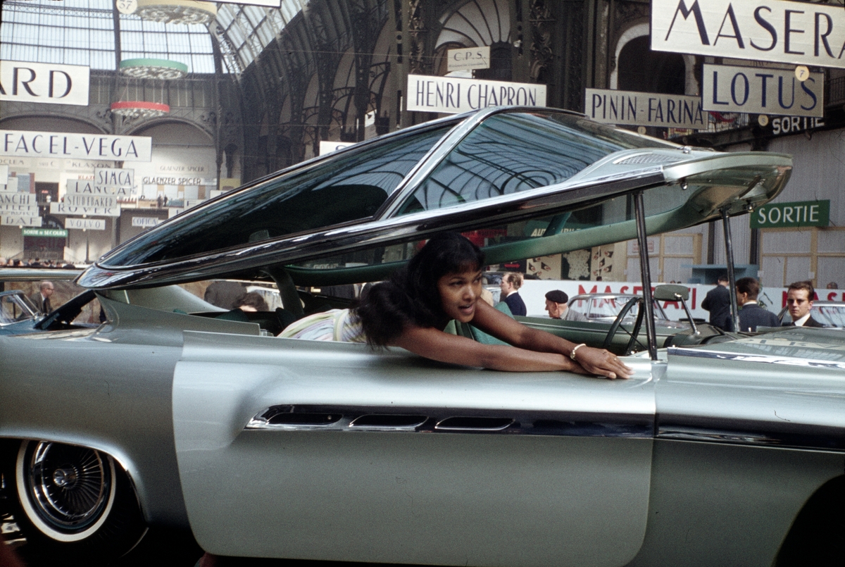 Foto fra en bilmesse i Frankrike. En kvinne presenterer en bil av ukjent merke.