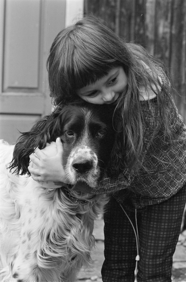 Portrett av et barn som koser med en hund.