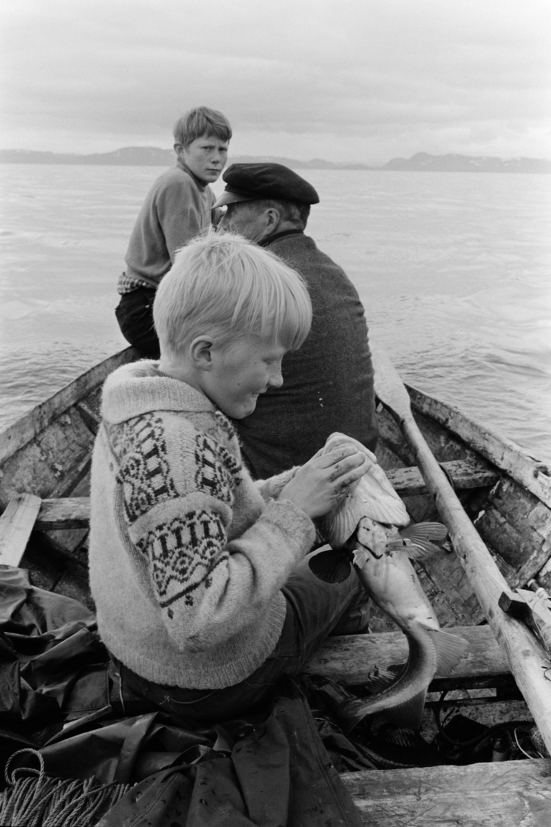 Gutter og eldre mann i båt.