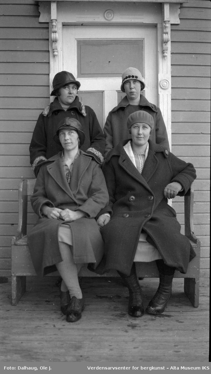 Lotta, Tora, Gunvor og Terese, overskyet, men lyst, kl 1/2 5. 15.april 1927. 4 unge kvinner foran et hus og en dør med utskjæringer rundt.
