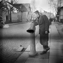 Storgata i Horten. Gutt lener seg mot en brannhydrant. 1948