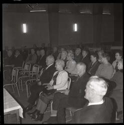 Fotografi av mange finkledde eldre menn og kvinner som sitte