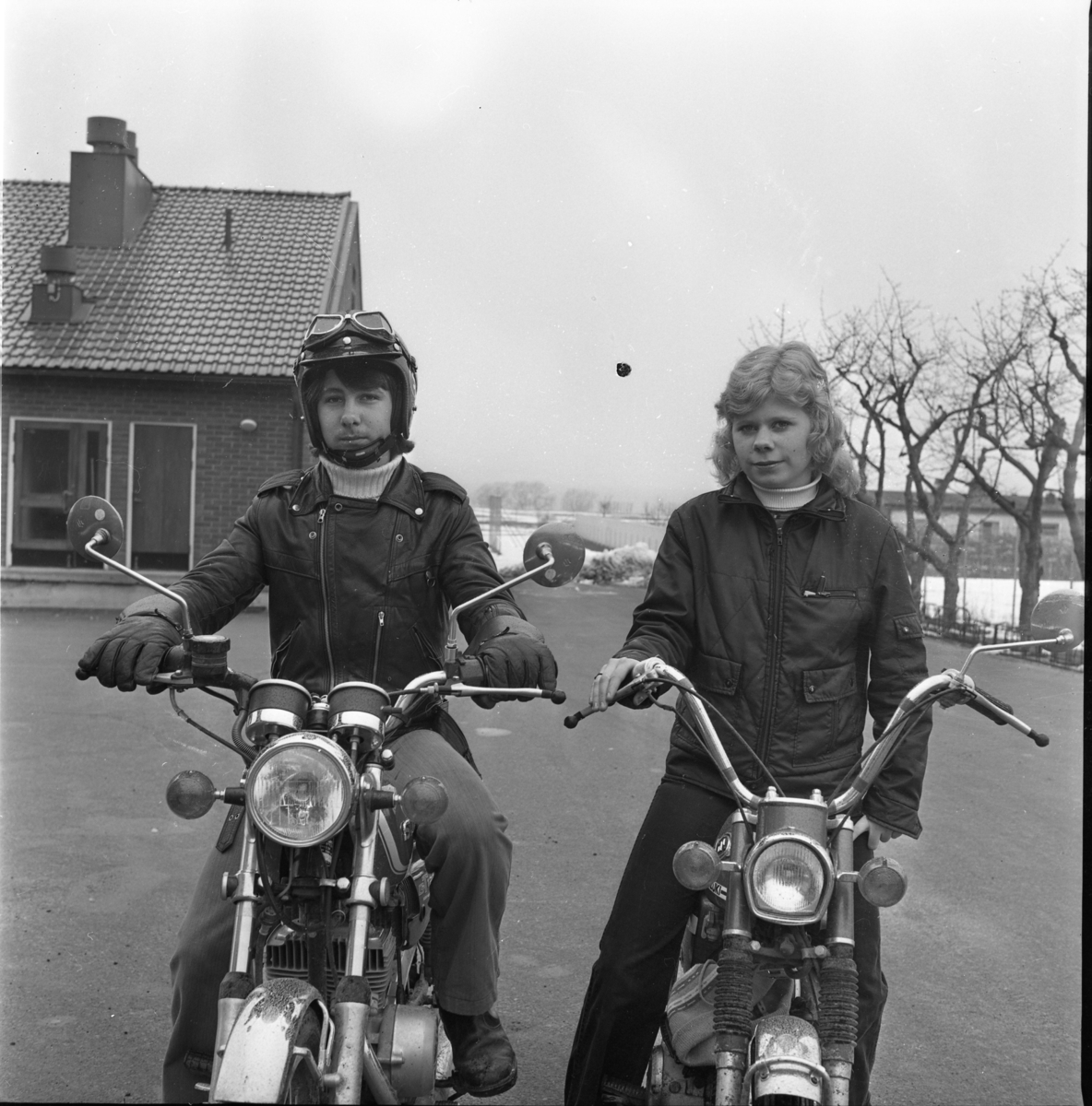 En pojke och en flicka sitter på varsin moped.