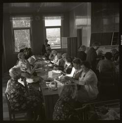 Fotografi av mange eldre kvinner som sitter ved et langbord 
