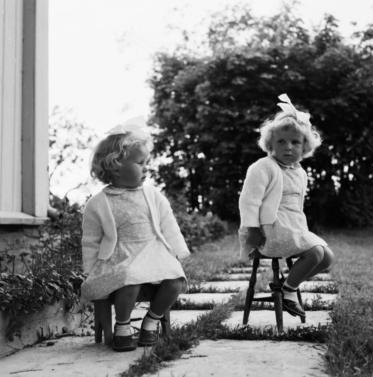 Fra Nordli, Sørum i Gjerdrum. To små jenter sitter på hver sin krakk.