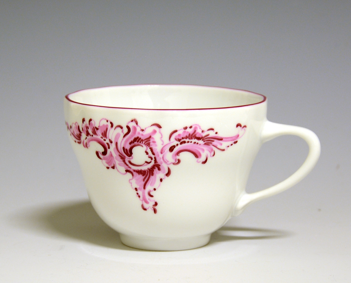 Kaffekopp av porselen. Håndmalte blomsterdekor, rosa blomster og grønne blader, gullstrek langs toppranden.
Modell: 1800, Victoria
Håndmalt dekor av Knut Andersen