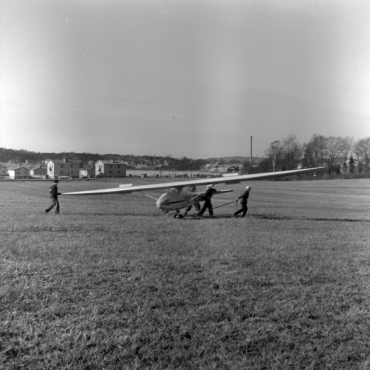 Segelflygplan har landat på gräsplan i Stockslycke. I bakgrunden syns Alingsås bomullsväveri på andra sidan Gerdsken. 1940-tal