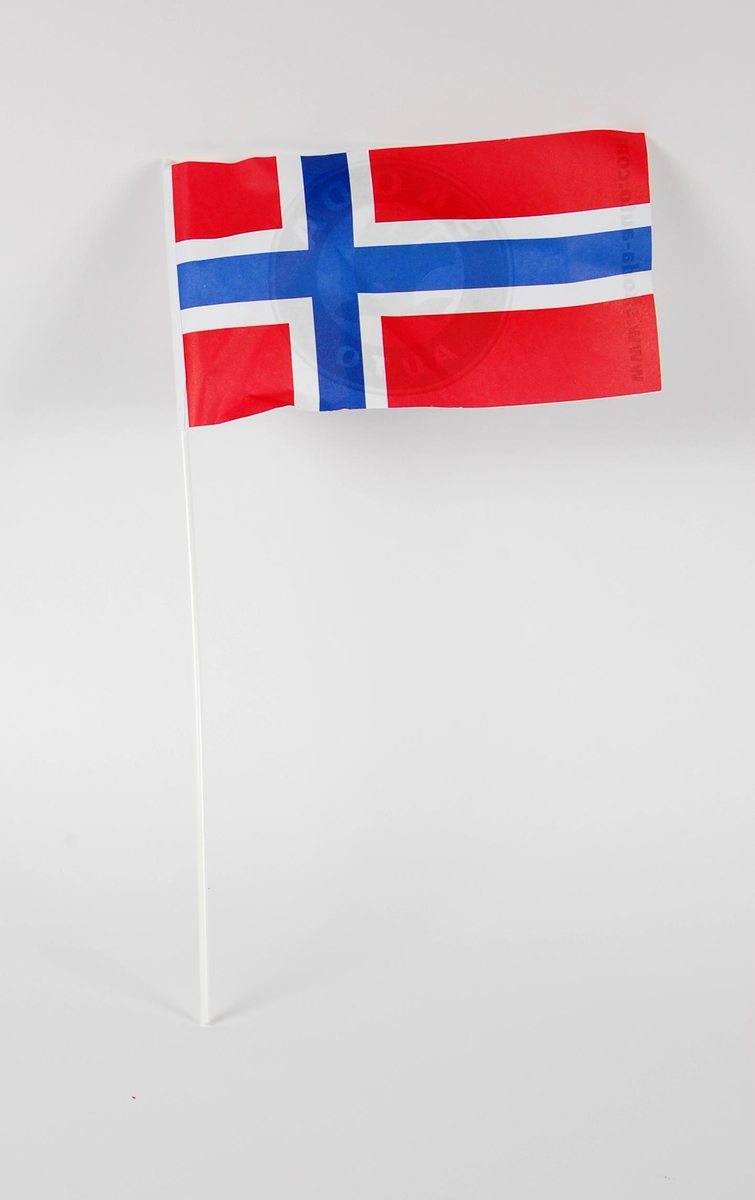 Norsk miniatyrflagg av papir. På baksiden er det en logo for Skoda. Flagget er festet på et plastrør.