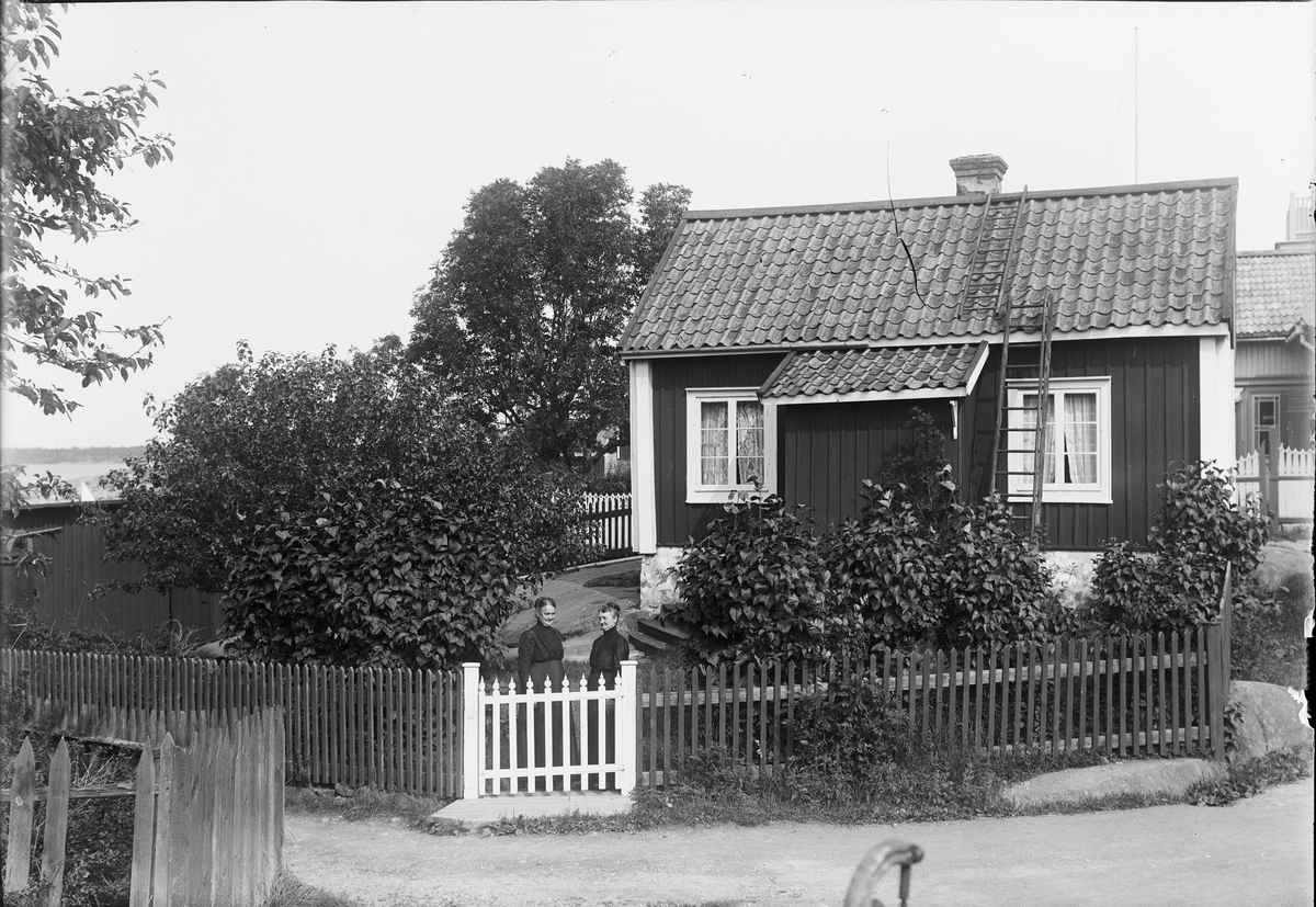 Kvinnor vid grind utanför bostadshus, Öregrund, Uppland