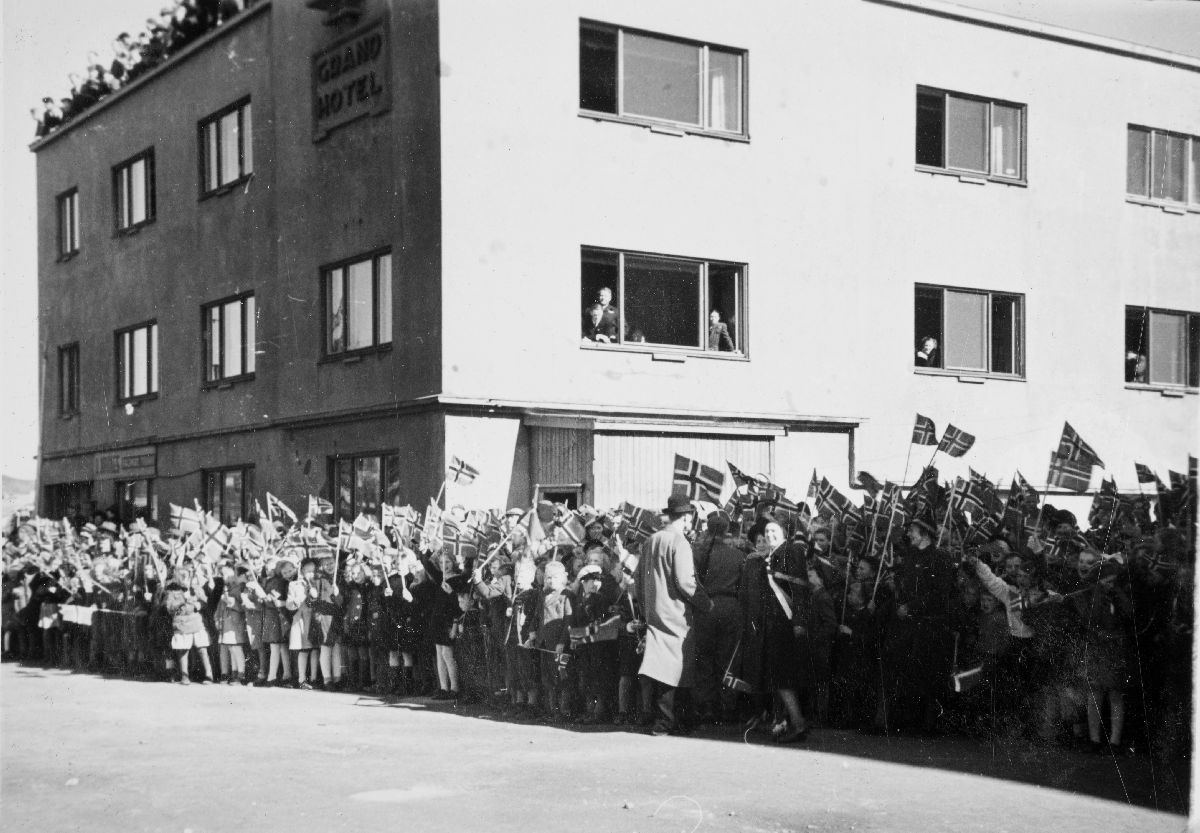 Opptog i Bodø sentrum 13. mai 1945. Byens befollkning gikk mann av huse for å ta imot de hjemvendte norsk polititroppene. Bak ses Grand hotell.