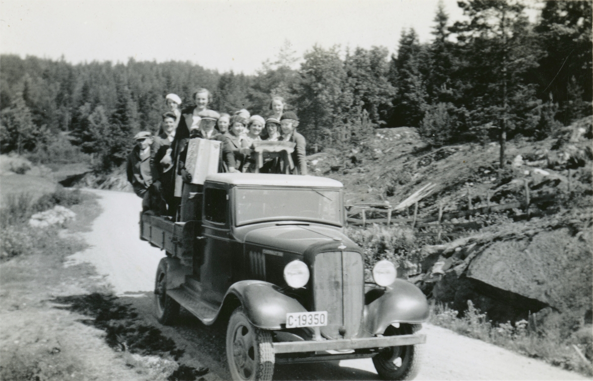 Ungdommer med trekkspill står på lasteplanet på en Chevrolet 1934-35-modell.