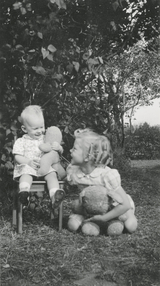 Barn i hagen med bamser.