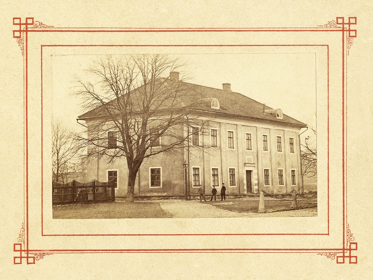 Det s.k. Karolinerhuset i Växjö, byggt som trivialskola, senare använt bl a som stiftsbibliotek.
Några pojkar har stannat till för fotografen.