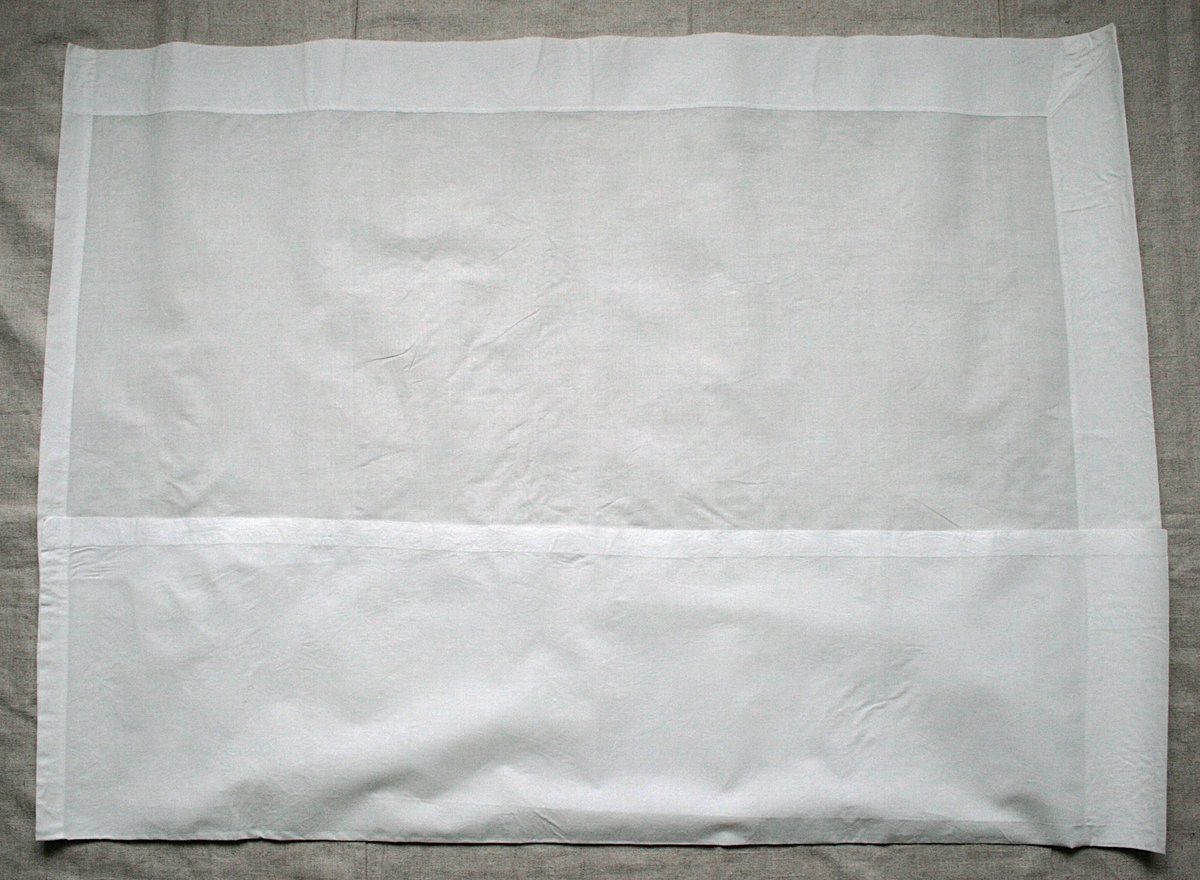 Kvadratiskt kläde av vitt, mycket fint linne. Klädet har bred fåll, 70 mm, på 2 motstående sidor och smalare fåll, 20 mm på 2 sidor.