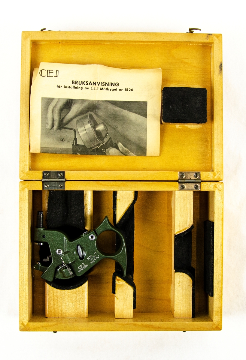 Mätbygel 1526-1
Grön verktyg i metall som förvarats i specialtillverkad trälåda. Lådan innehåller bruksanvisning på svenska. Bygeln skall användas i samband med ett visarinstrument t.ex. en Mikrokator.