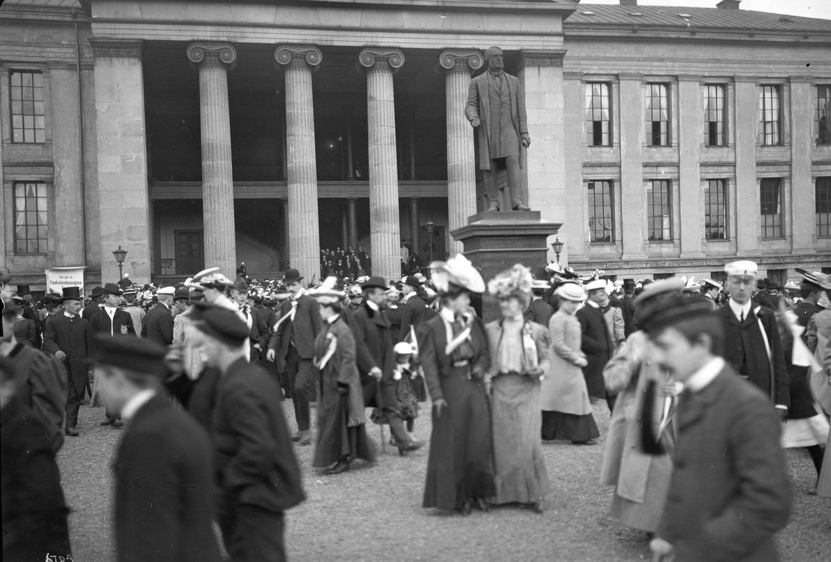Mange mennesker på Universitetsplassen og sangkor i Aulaen 17. mai 1907.