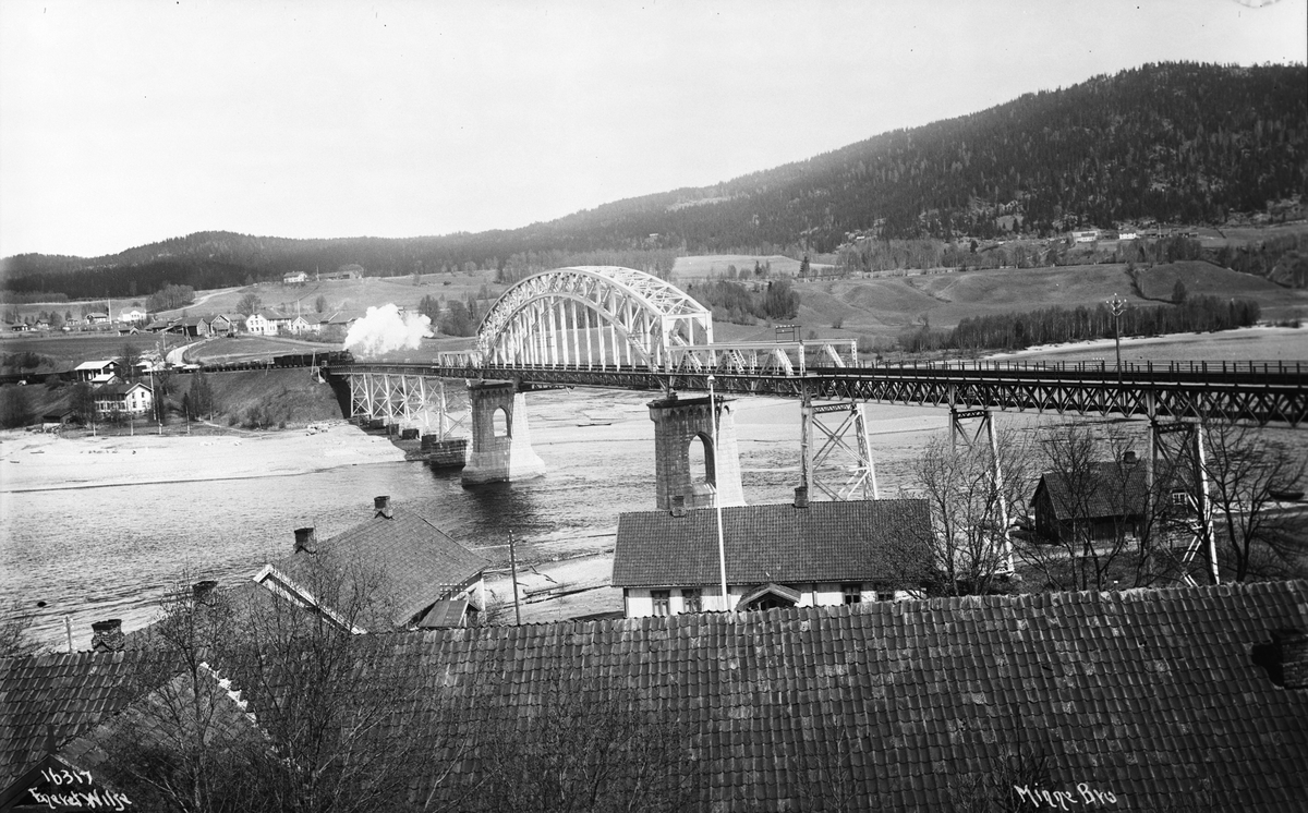 Damplokomotiv med gods- og passasjervogner på vei nordover over Minne jernbanebro som markerer utløpet av Mjøsa og overgangen til elva Vorma, Minnesund, Eidsvoll, Akershus, 1914.