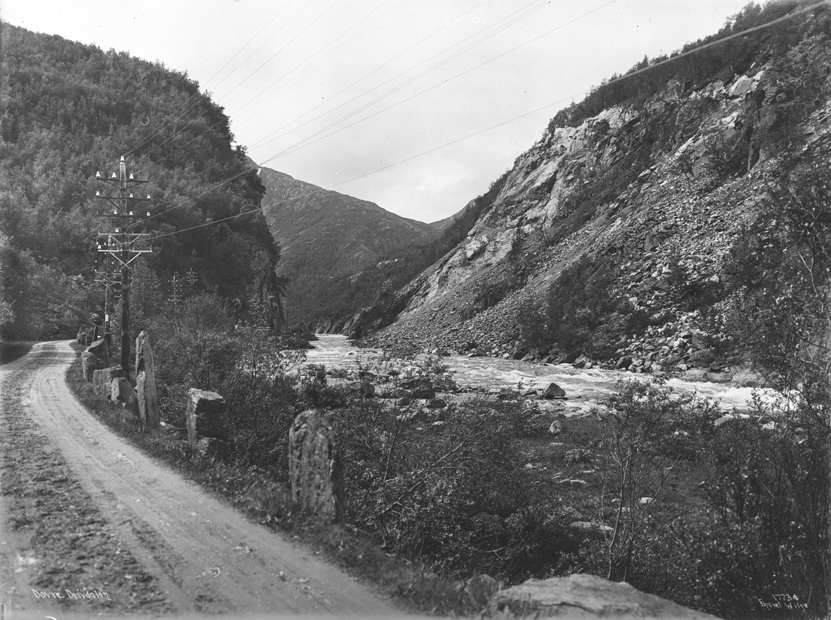 Elva Driva i Drivdalen, Oppdal, Trøndelag, og vei med strømmaster, 1915.
