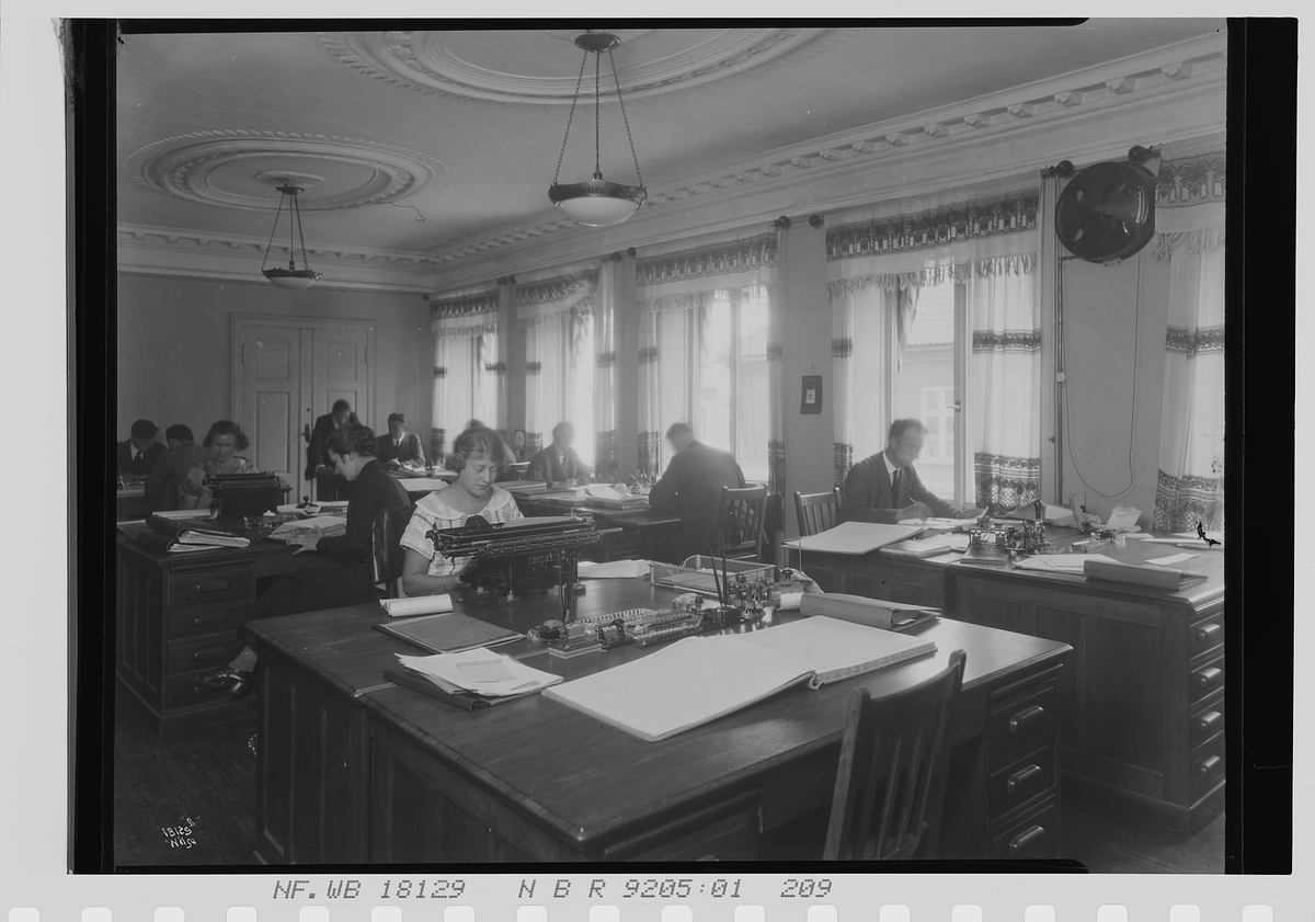 Kvinner og menn sitter sammen på et stort kontor, Vinmonopolet. Fotografert 1924