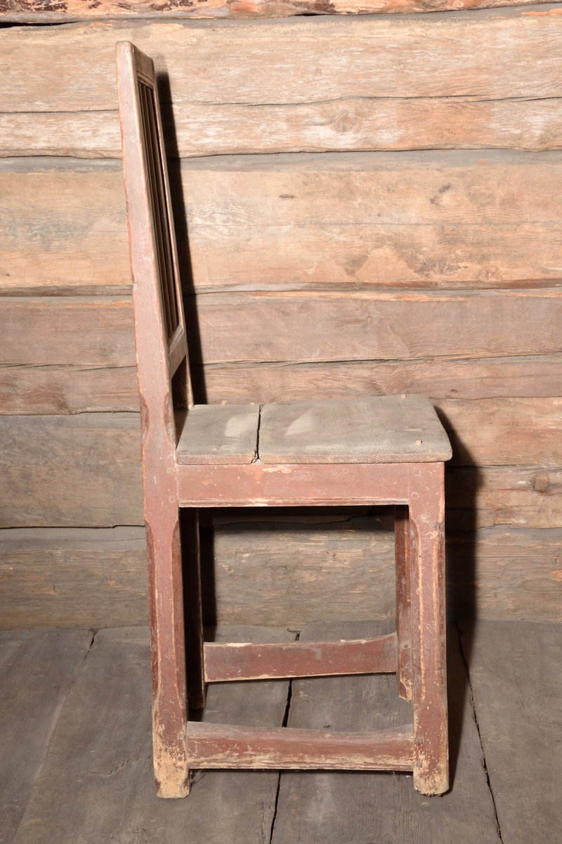 Stol tillverkad i trä, rödmålad. Rektangulär ryggbricka, delvis genombruten med tre spjälor. Enkel ostoppad sits. Stolen står på fyra raka ben, med delvis fasade hörn. Benen nederst sammanhållna med fyra stabiliserande slåar.