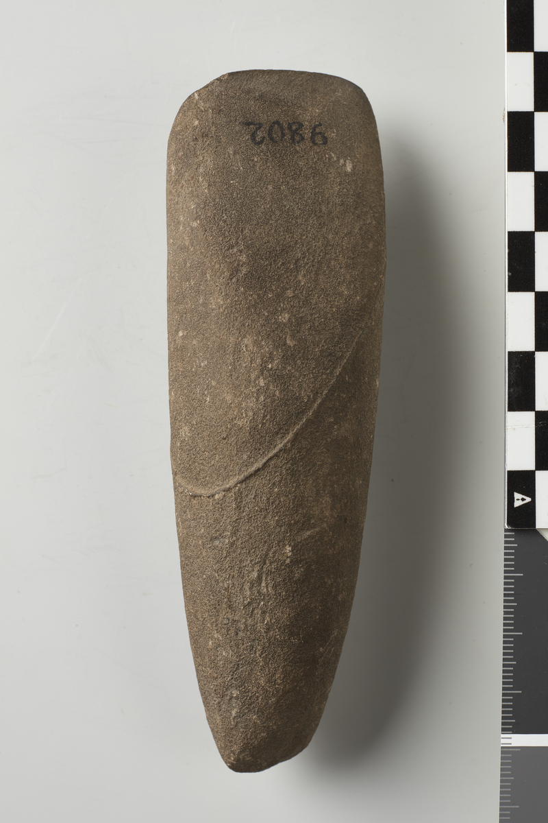 Kile af Sten, samme Form, meget spids Bane, skraasleben ved Eggen paa begge Sider, 12. 8 cm. lang.