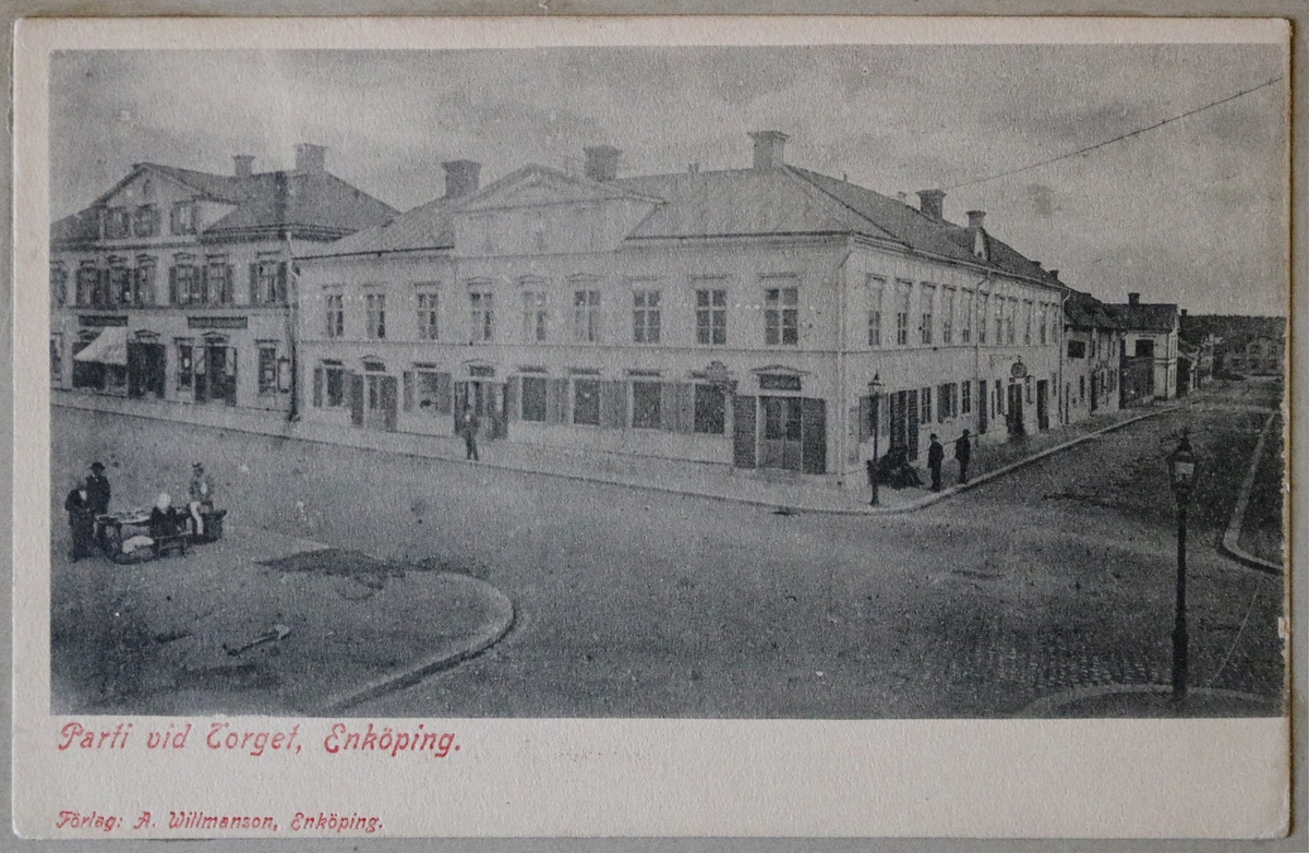 Vykort med motiv från korsningen Kungsgatan-Källgatan vid Stora torget, Enköping, omkring 1900. 

Detta vykort sitter inklistrat i vykortsalbum nr. EM6774:b och är albumets tredje vykort.