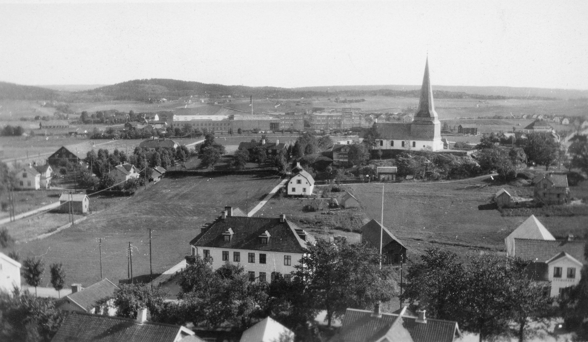 Flygfoto över Söndrum med kyrka och kyrkogård med  omgivande bebyggelse och havet i bakgrunden.