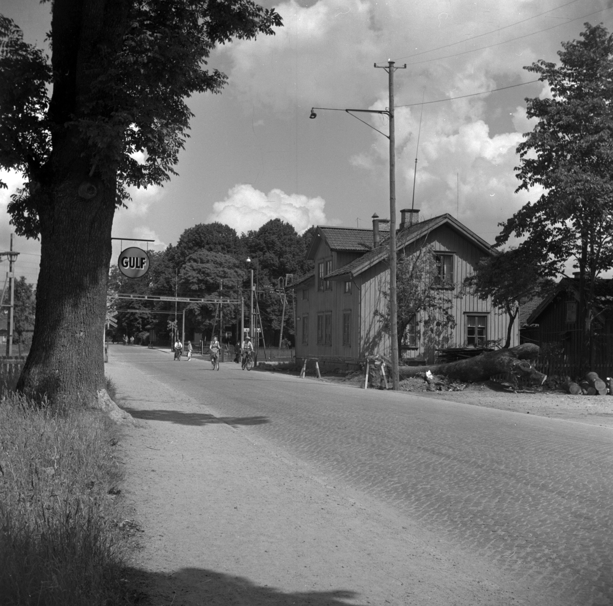 Göteborgsvägen och järnvägsövergången. Till höger kv Hammaren till vänster skylt för bensinstationen Gulf. 1940-talets slut.