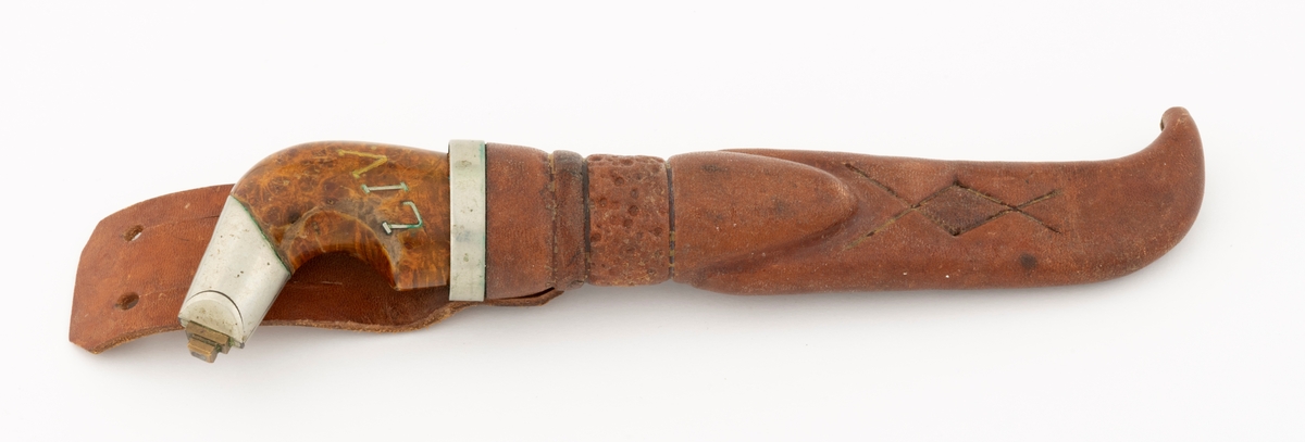 Tollekniv med slire, lagd av knivmakeren Gustav Lutnæs (1897-1975) fra Trysil i Hedmark. Knivbladet er 8,2 centimeter langt, 1,7 centimeter bredt (ved brystningen) og 1,9 millimeter tjukt. Det har 5,5 millimeter brede slipefaser på begge sider. Bladryggen er rett, men en aning avfaset i den fremre enden. Egglinja er konvekst buet i den fremre enden. Knivbladet har ikke smedstempel. Skaftet er laget av et trestykke med spesiell vedstruktur, sannsynligvis fra en utvekst på rot eller stamme. Treet er innsatt med lysebrun beis, som framhever vedstrukturen, og overlakkert med klarlakk. Skaftet har en form som er karakteristisk for Lutnæs og hans elev Koll Granli (1922-2011). Tverrrsnittet er ovalt, tjukkelsen tiltar jevnt fra den fremre enden og et stykke bakover (her cirka 6 centimeter), hvor det ee et buet hakk på skaftets bukside, hvor brukeren fikk godt grep med lillefingeren. Den bakre enden av skaftet er bøyd mot buksida, noe som forutsatte en spesiell teknikk med gjennomføring av en bøyd tange i forlengelsen av bladet. Det er forsterkende nysølvholker i begge ender av skaftet. Den fremre er 2,6 centimeter langt og har skråfaser mot bladets flatsider. Den bakre holken er 2,6 centimeter lang, målt langs bakre ytterkant. I ytterenden av denne holken er det et par rektangulære messingskiver som er klinket mot enden av tangen. Den ene sida av skaftet har et innlegg, jentenavnet «LIV» etter den Lutnæs lagde kniven til.

Slira er sydd av lysebrunt lær med en søm som var skjult når redskapet ble hengt i beltet. Formen er asymmetrisk og gjenspeiler formen på knivbladet, men med en markert sidevendt tupp i den nedre enden, som skulle skjerme knivodden. Den nedre delen av slira er forholdsvis flattrykt og har et mønster - to plogformer sok krysser hverandre, slik at det har oppstått et parallellogram på midten. Den øvre delen av slira er mer «rundoval», en form som er tilpasset skaftets tverrsnitt. Her er det pautet et slags belte med prikkmønster, med en liten vulst over. Rundt sliremunningen er det et 6 millimeter bredt nysølvbeslag. På baksida av denne sliredelen er det pånaglet en lærstropp med to spalter som skulle gjøre det mulig å tre den inn på et belte.