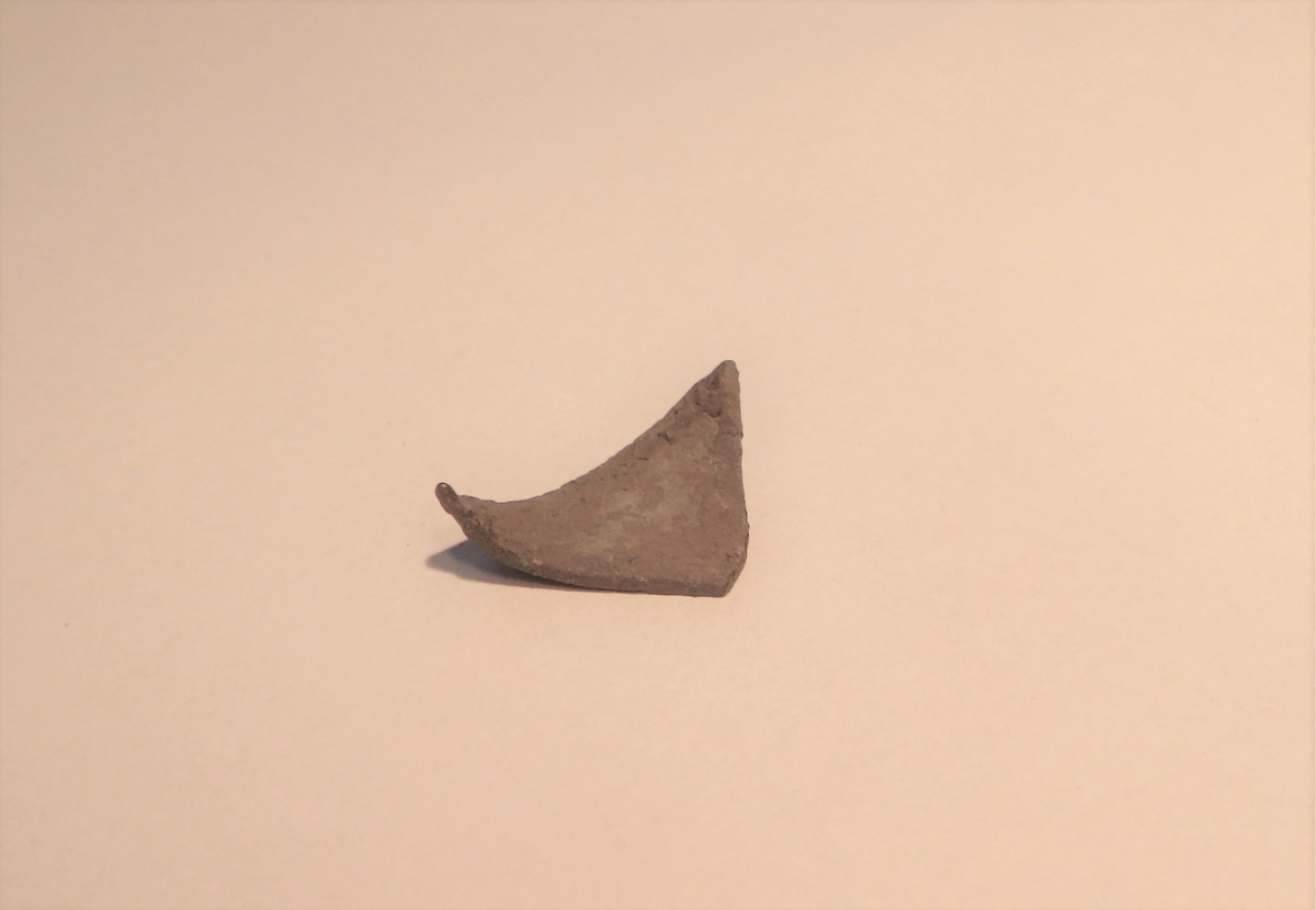 En liten trekantet metallplate, et plateavklipp fra verksted.