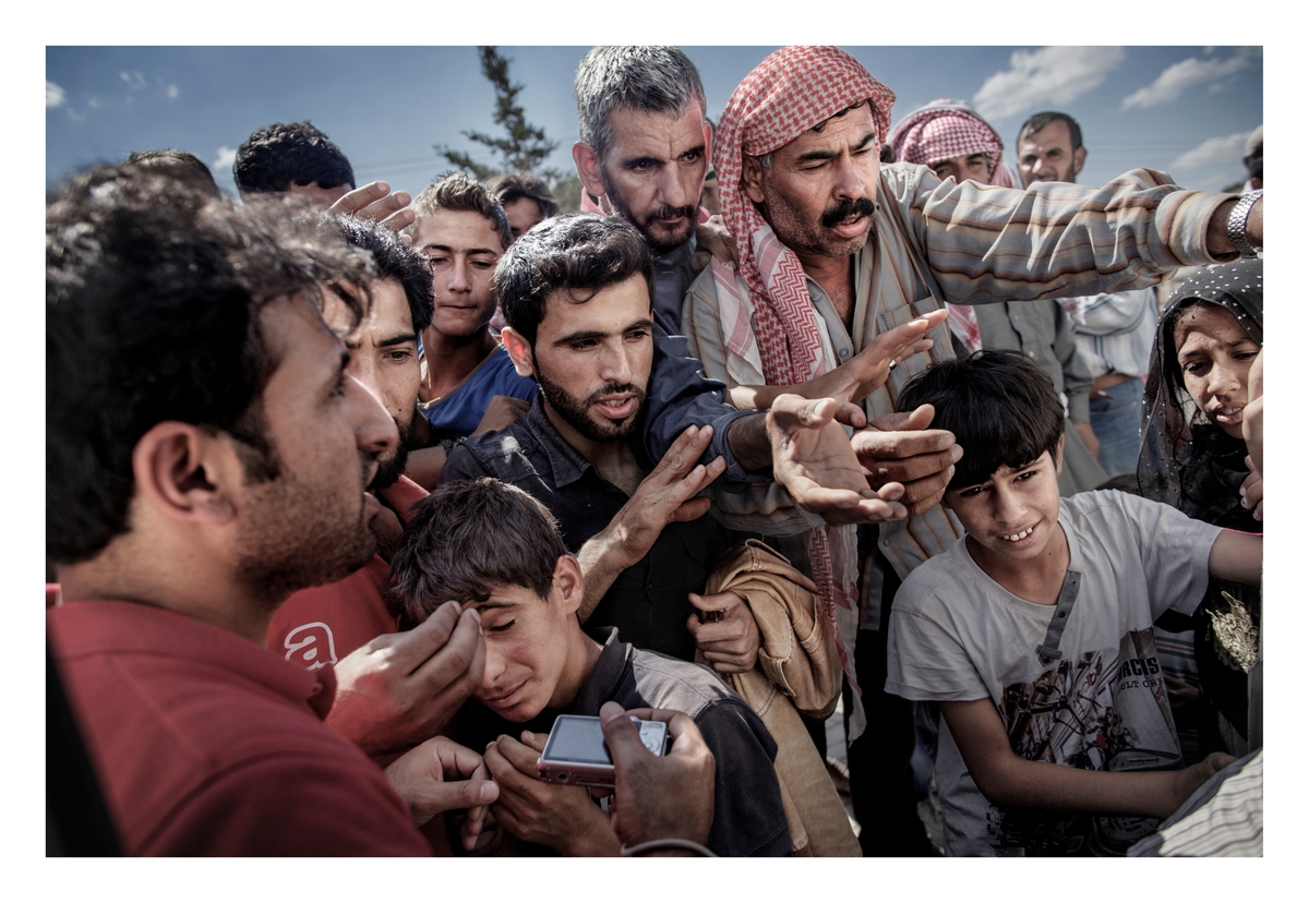 Syriske flyktninger venter ved en varebil hvor frivillige deler ut vann og såpe i grensebyen Akcakale på grensen mellom Tyrkia og Syria. Tusenvis av flyktninger krysset grensen for å unnslippe vold og borgerkrigen i Syria og for mange er denne byen starten på en lang flukt mot nord-Europa.