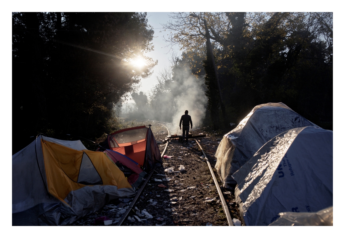 Flyktninger og migranter bor i en midlertidig teltleir på den greske siden av grensen mellom Hellas og Makedonia. Etter den store flyktningstrømmen sommeren 2015, ble det bygget et grensegjerde og store vaktstyrker utplassert, noe som gjorde reisen mye vanskeligere. Kun syrere, irakere og afghanere fikk lov å krysse grensen, tusener av andre ble tvunget til å leve i kulden og under dårlige forhold langs nedlagte jernbanelinjer.